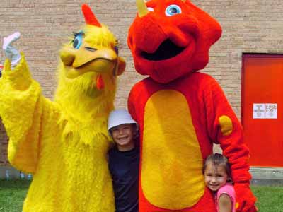 Dinosaur and bird mascot posing for photo